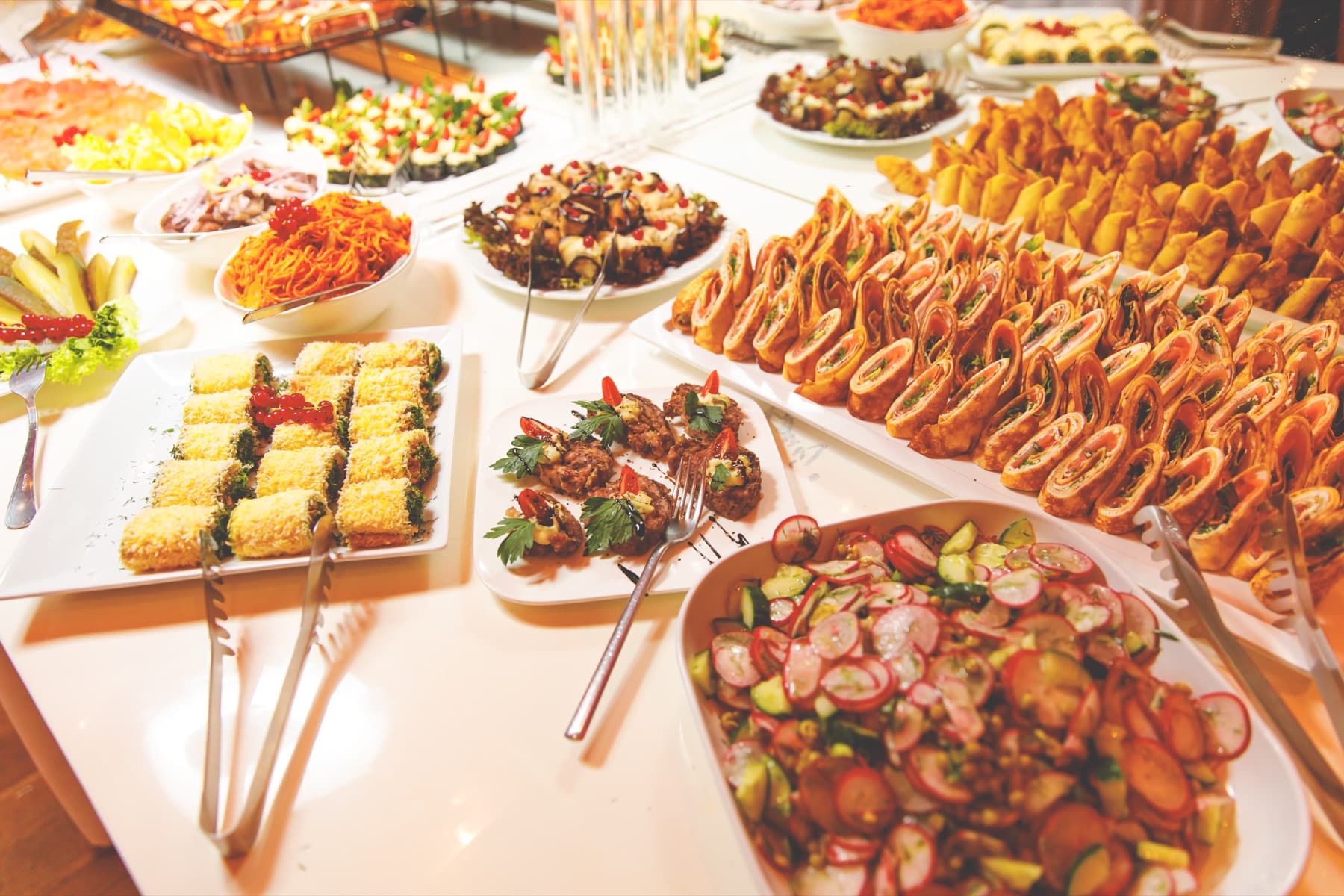 Reich gedecktes Buffet mit Salaten, Röllchen und warmen Speisen
